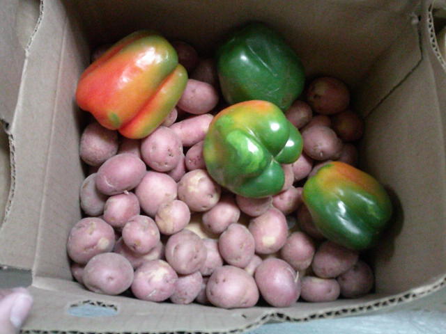 A box containing red potatoes and bell peppers..